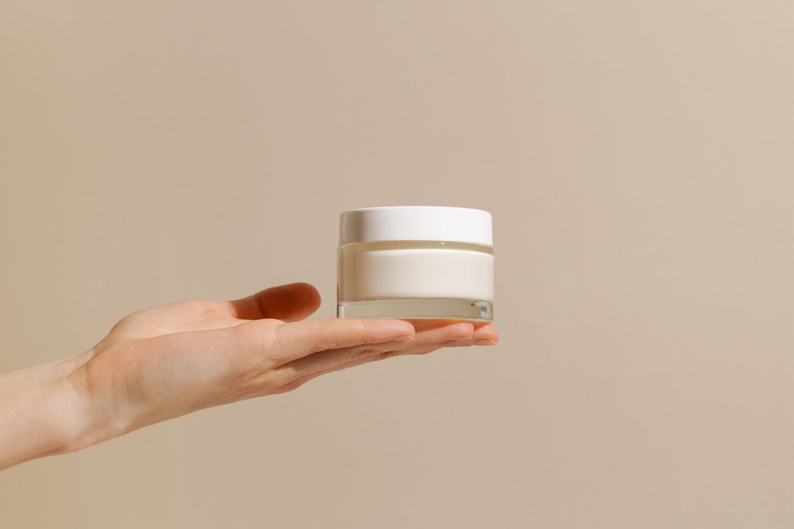 Moisturizer jar on open palm